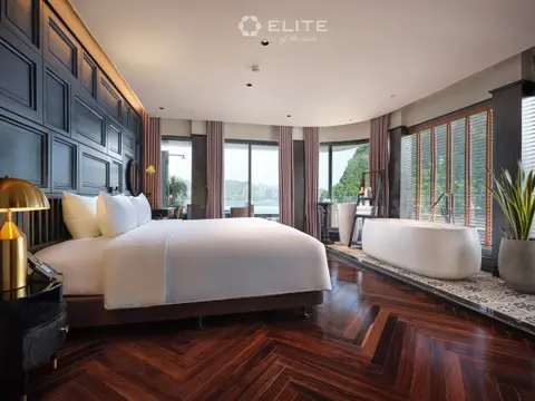 Executive suite with a double bed and a freestanding bath set in front of the windows