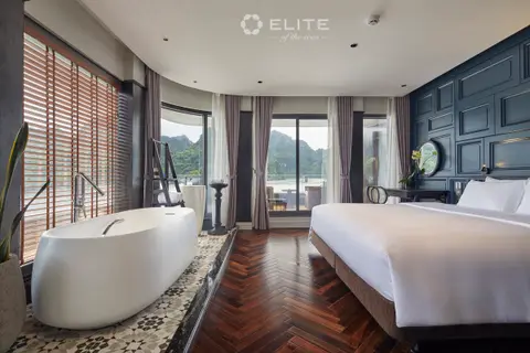 Executive suite bathtub on a patterned tile floor next to a window wall over the water