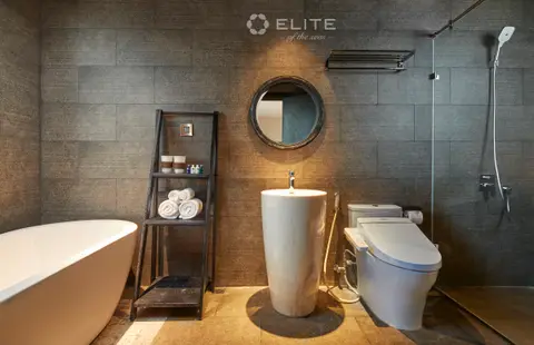 Premium cabin bathroom in grey stone with a freestanding bath, stone basin and walk-in shower
