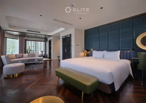 President suite with a bed, curved sofa and windows running the full width of the room
