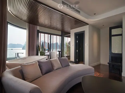 Curved grey sofa in the President suite's lounge under a slatted ceiling