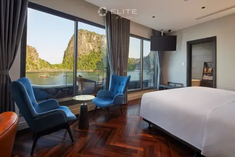 Senior Premium cabin with two blue armchairs at floor-to-ceiling windows facing a karst
