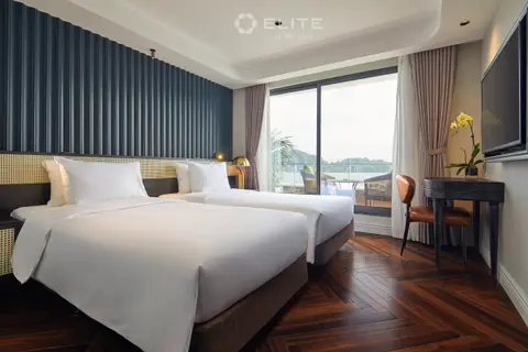 Senior cabin with twin beds against a ribbed navy wall and a wide window onto the bay