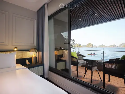 Senior cabin bed beside the open balcony door, looking out to the water