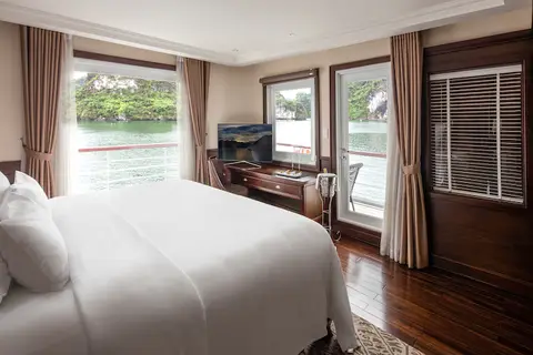 Сьют Elegance Balcony: кровать, письменный стол и ряд окон вдоль внешней стены