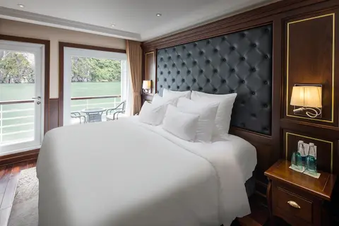 Каюта Executive Balcony на верхней палубе: двуспальная кровать напротив широкого окна на открытую воду