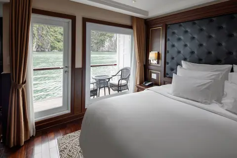 Две односпальные кровати в каюте Executive Balcony, снаружи видны стол и стулья на балконе