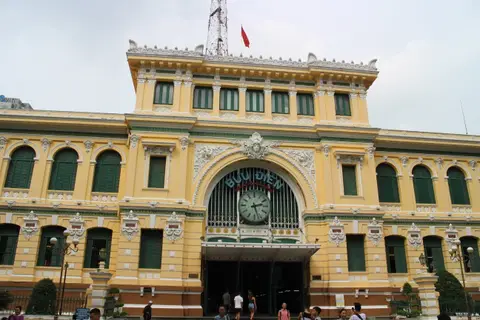 Yellow colonial-era post office building with arched windows and a large clock above the entrance