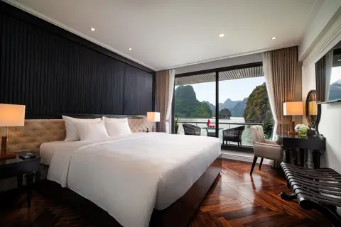 高级套房配备一张双人床，深色镶板墙，落地窗俯瞰海湾