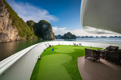 船首甲板上的人工草坪推杆果岭，旗帜和海湾在远处