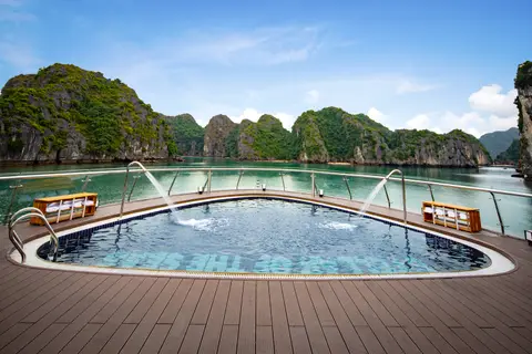 顶层甲板上的弧形户外泳池，背后就是海湾和石灰岩岛屿